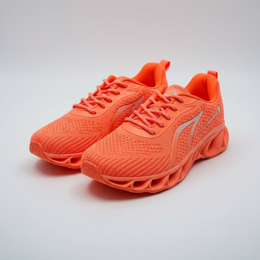 Pair of orange running shoes on a dark surface
