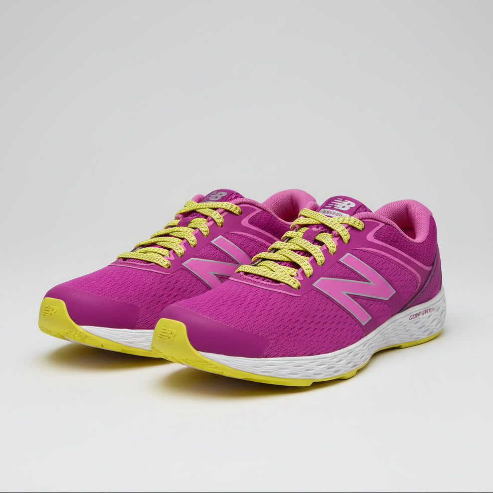 Purple running shoe with yellow laces on a cardboard surface