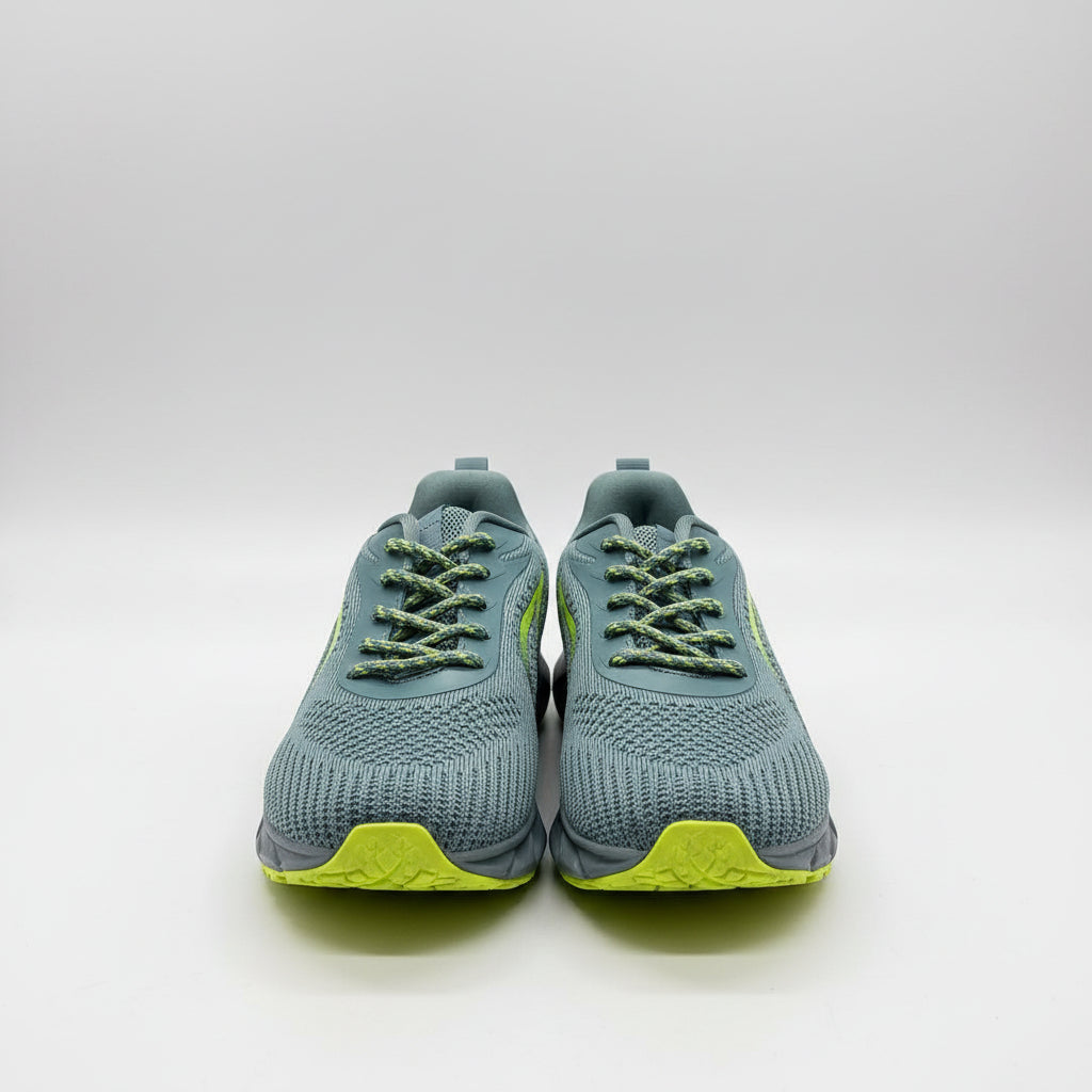 Pair of gray athletic shoes with green accents on a dark surface