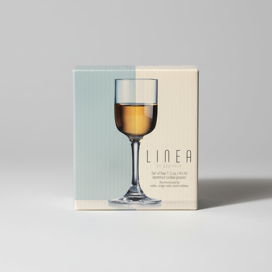 Product packaging with a wine glass illustration on a dark surface