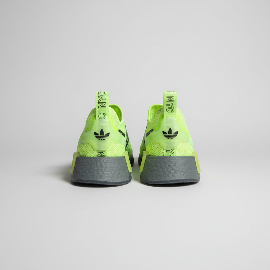 Pair of neon green and gray shoes on a cardboard surface with a blurred background.