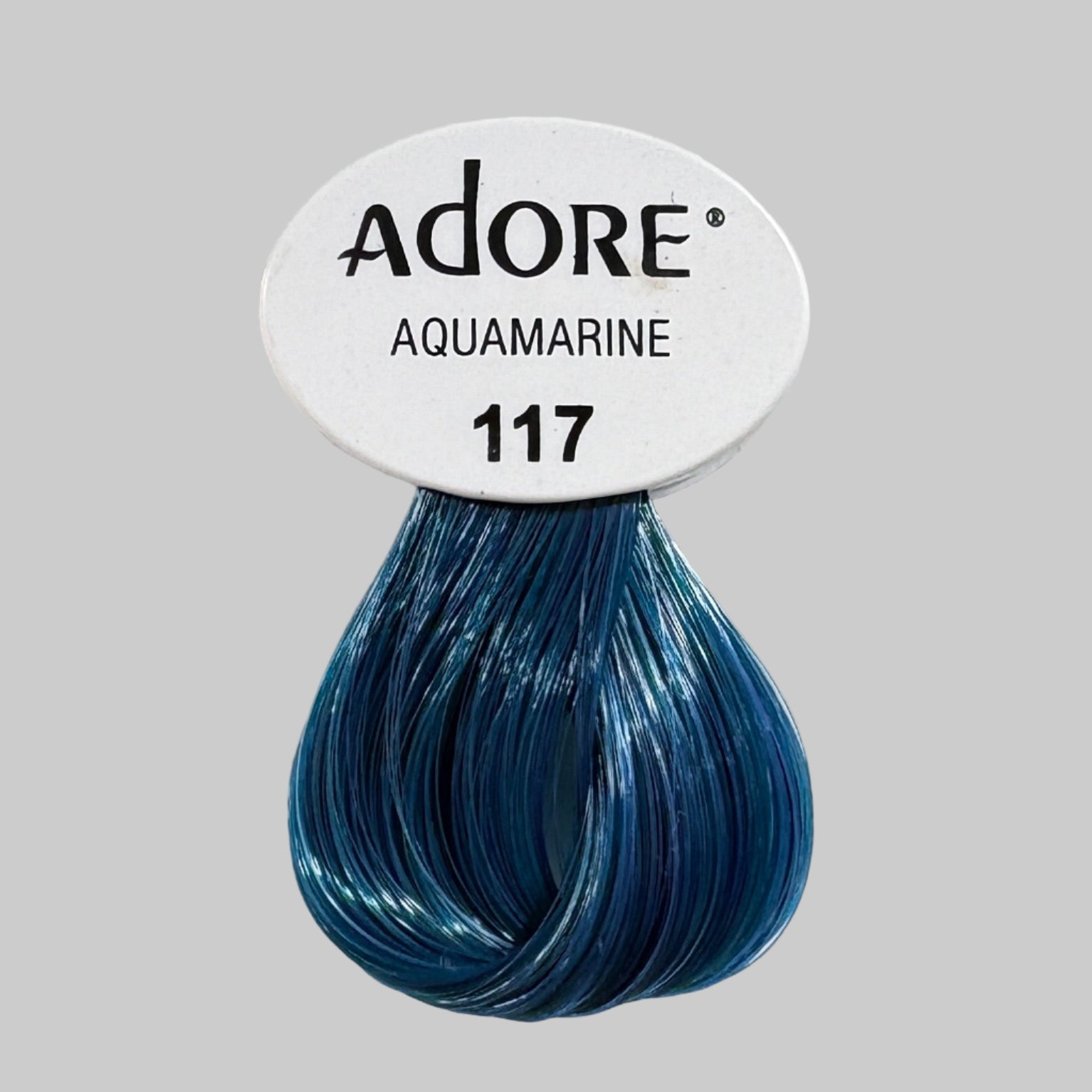 Adore Aquamarine hair color packaging with a blue sample on a shelf.
