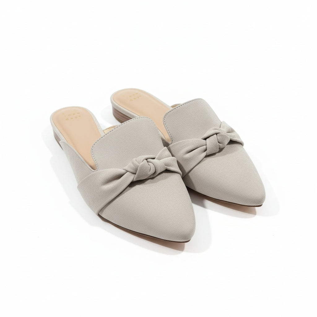 Pair of gray high-heeled shoes on a beige surface