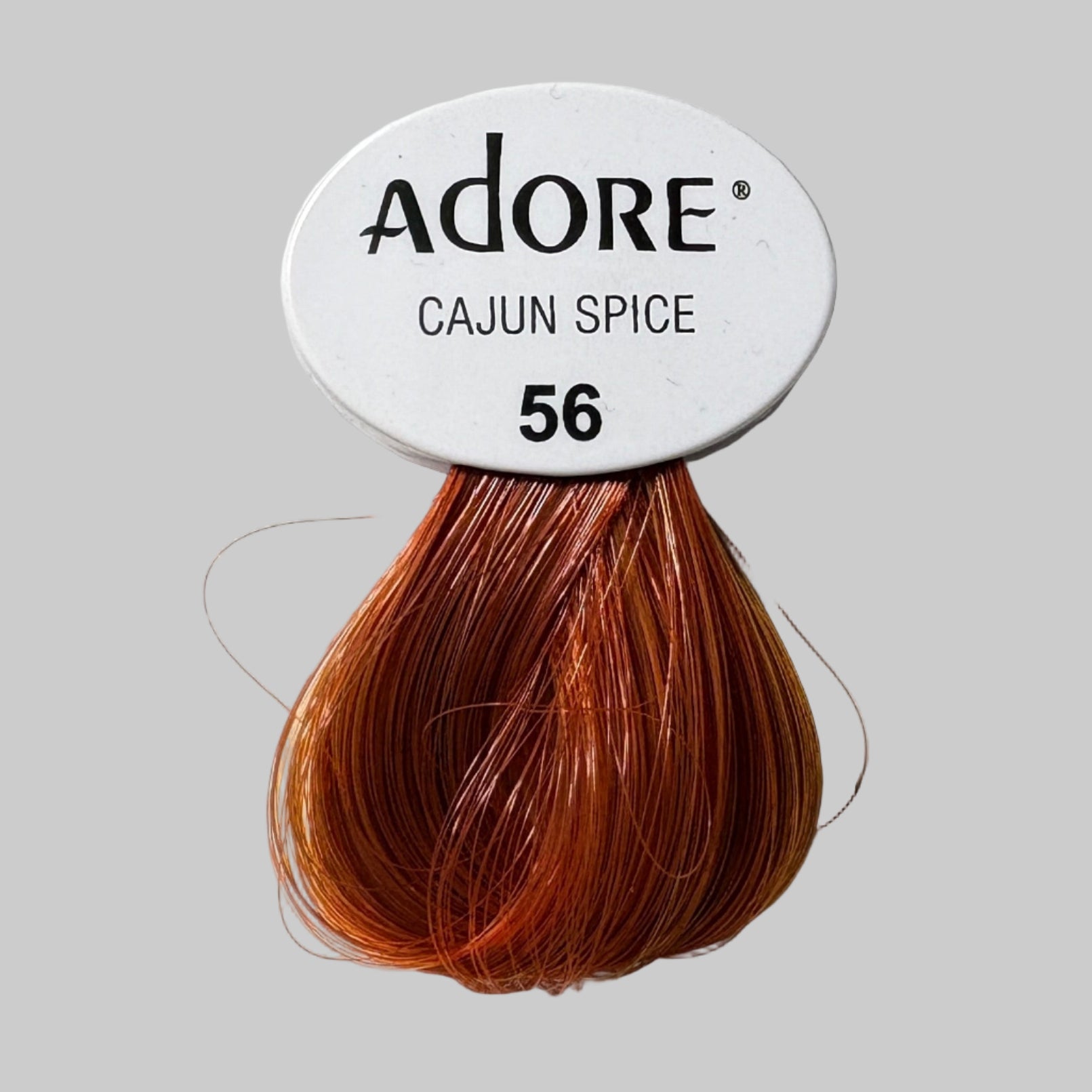 Adore Cajun Spice hair color packaging with other hair color boxes in the background.
