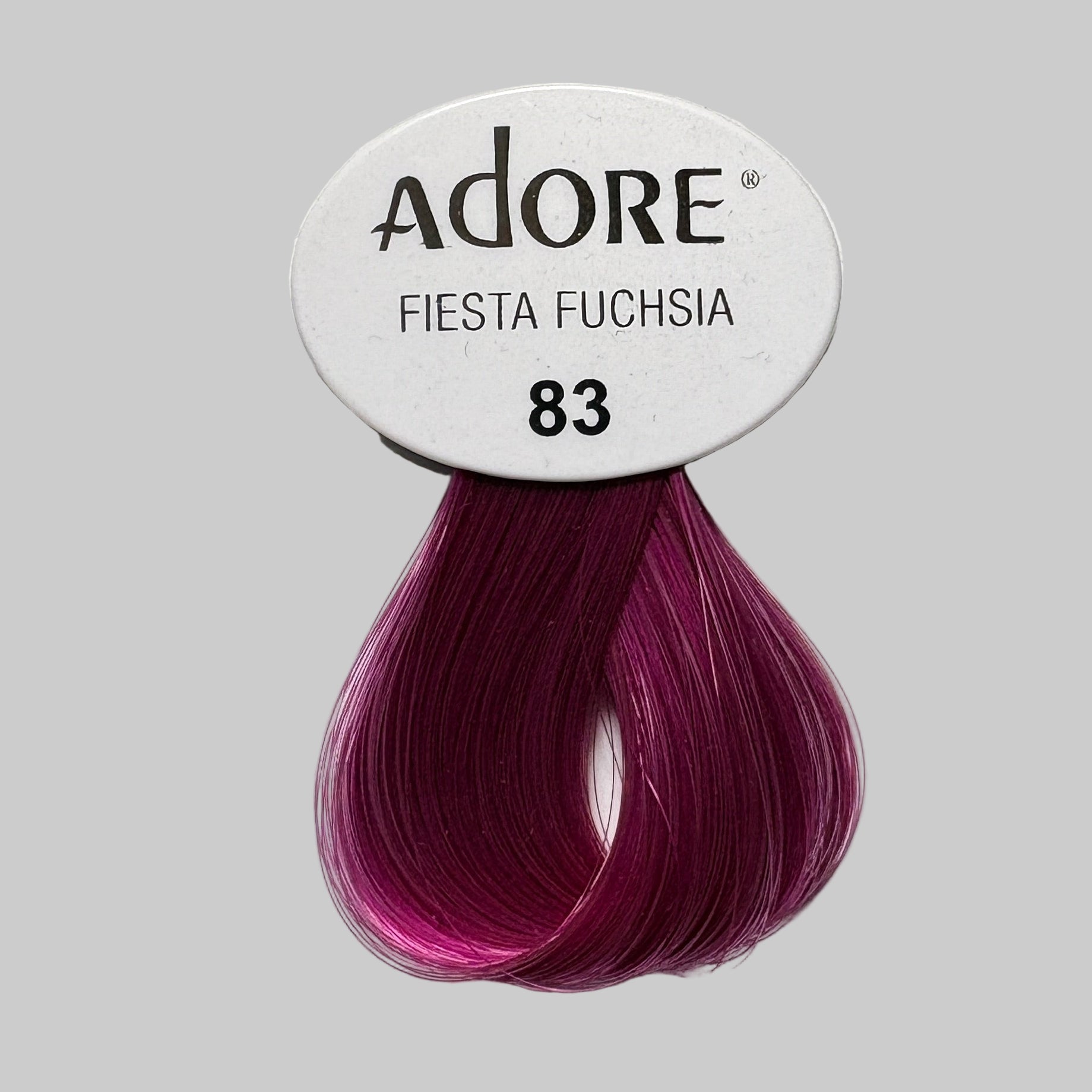 Adore Fiesta Fuchsia hair color package on a shelf with other hair color products.