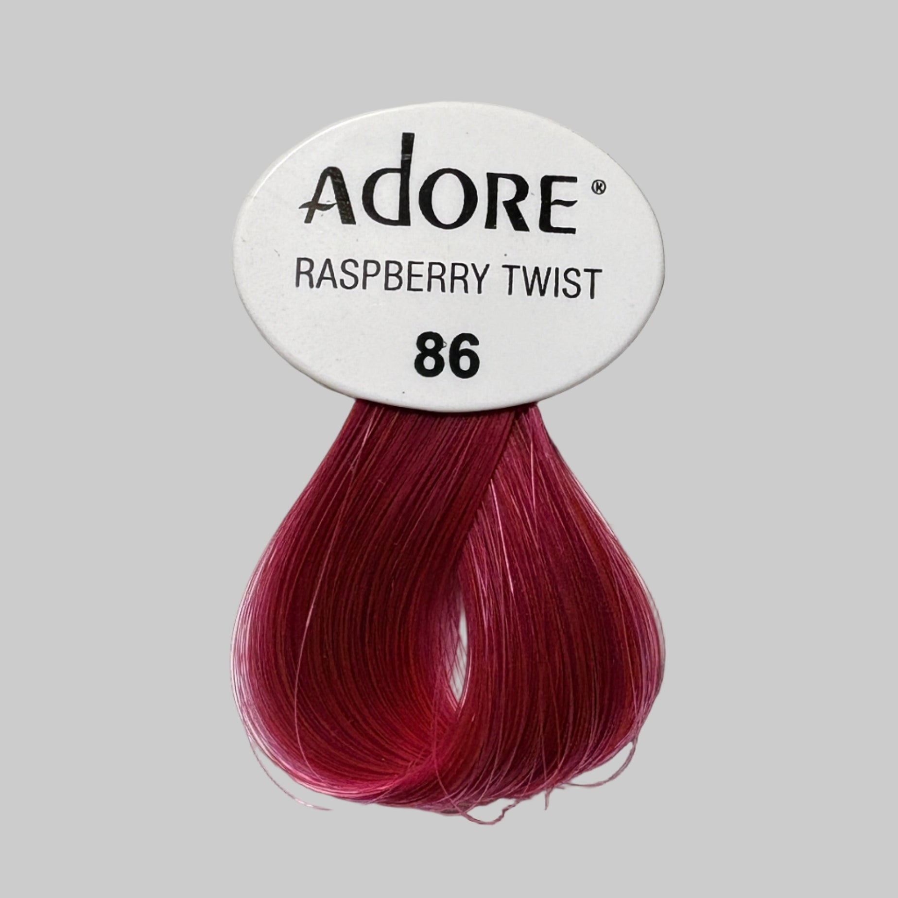 Adore hair color packaging with raspberry twist shade on a shelf.