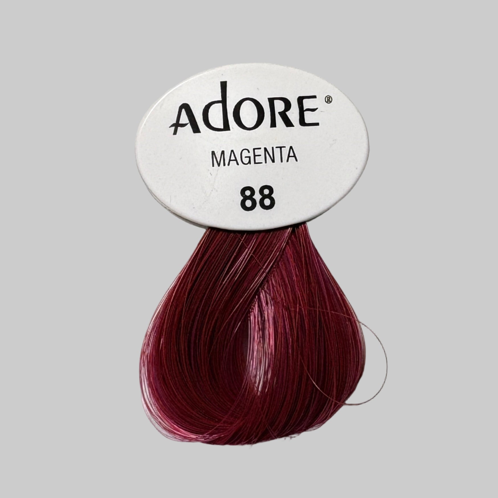Adore hair color packaging with a magenta shade on a store shelf.