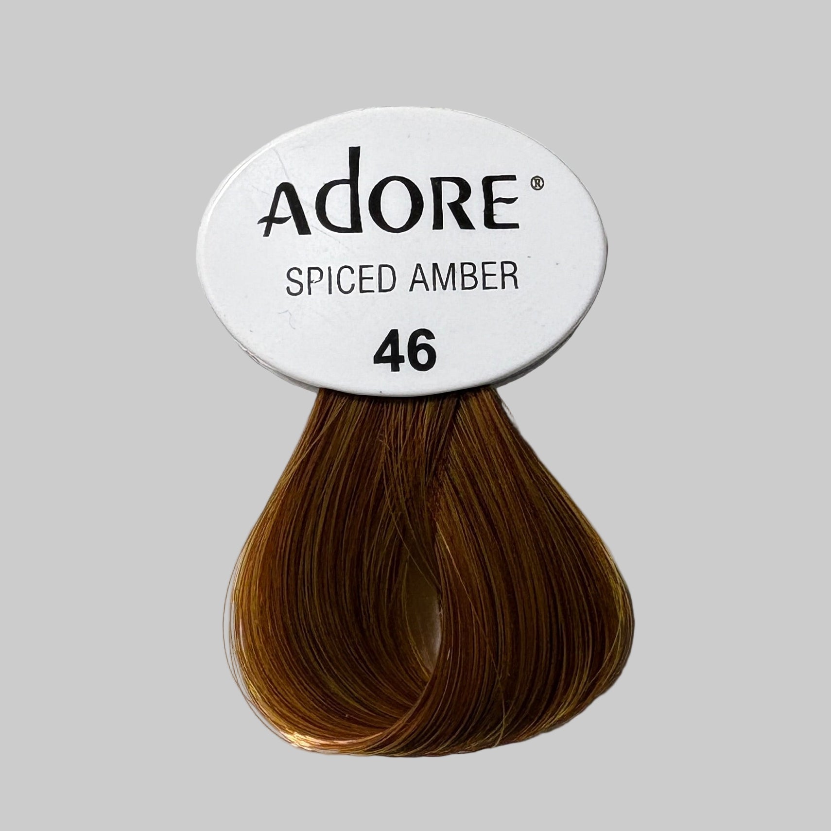 Adore Spiced Amber hair color packaging on a store shelf with other hair color products.