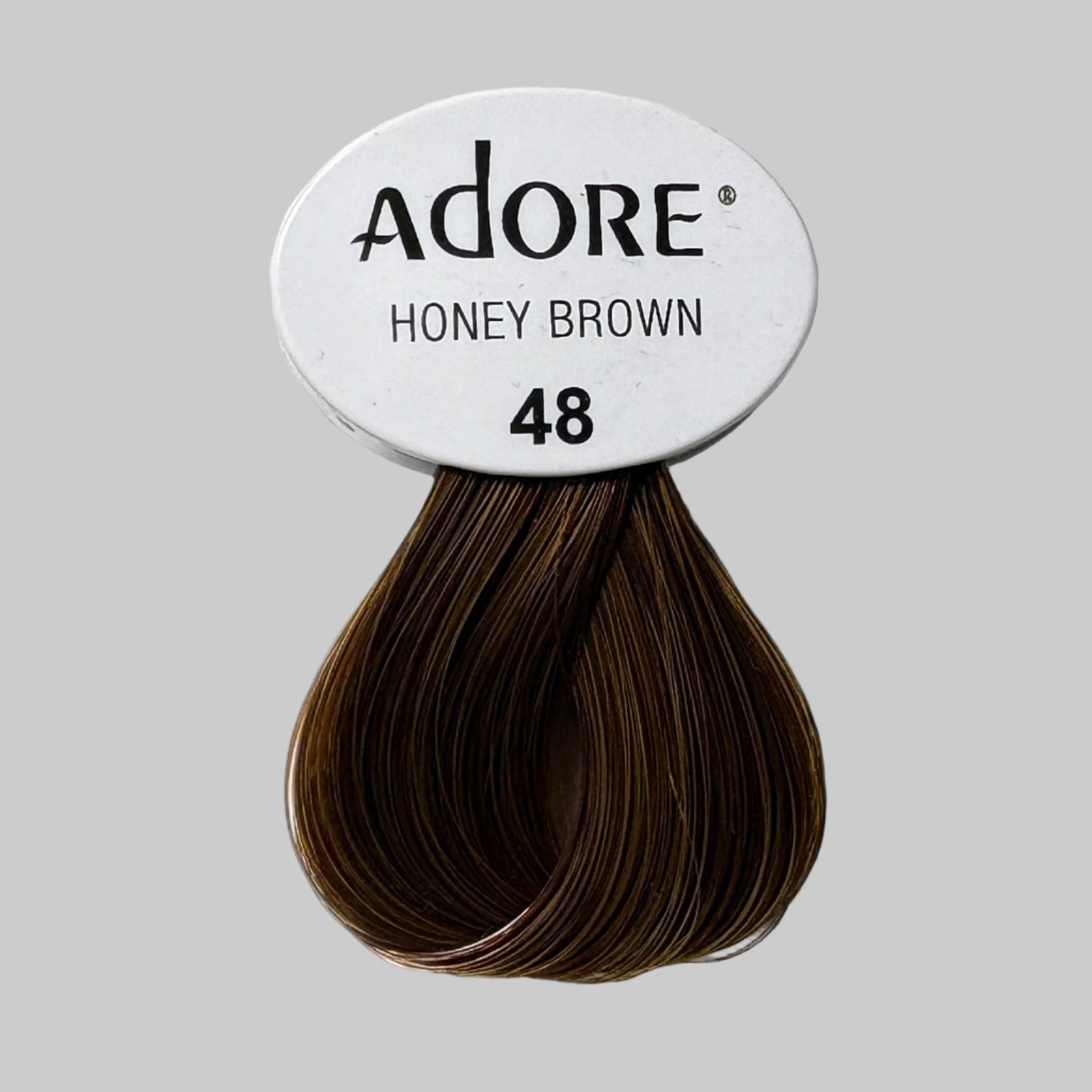 Adore hair color packaging with honey brown shade on a shelf.
