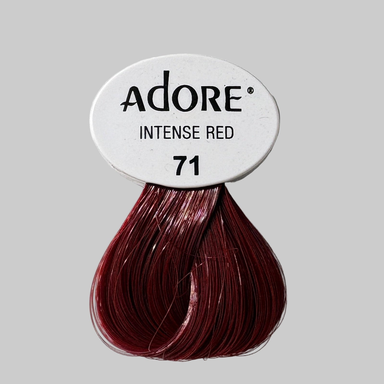 Adore hair color packaging with red hair dye packets on a shelf.