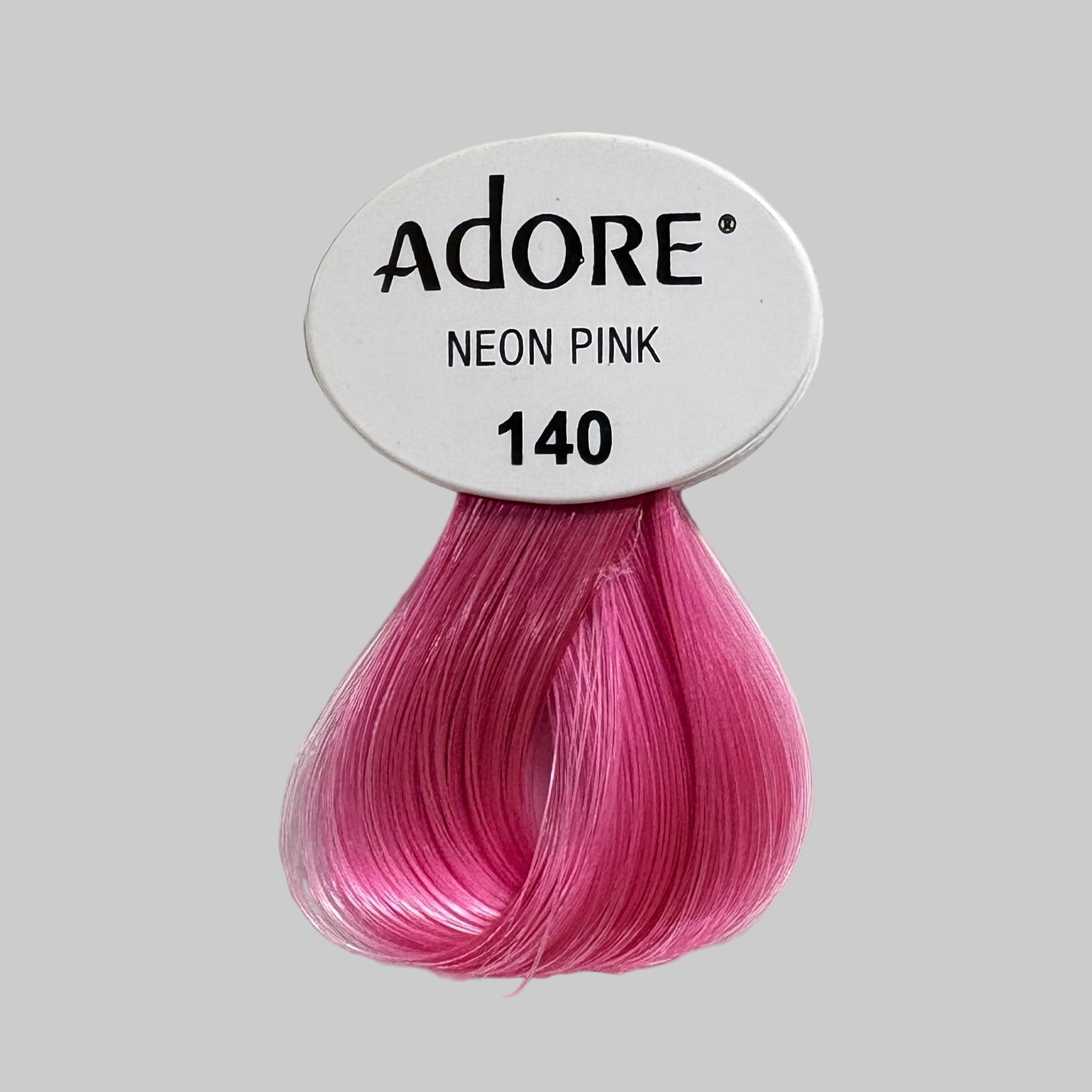 Display of Adore hair color with pink sample and product packaging.