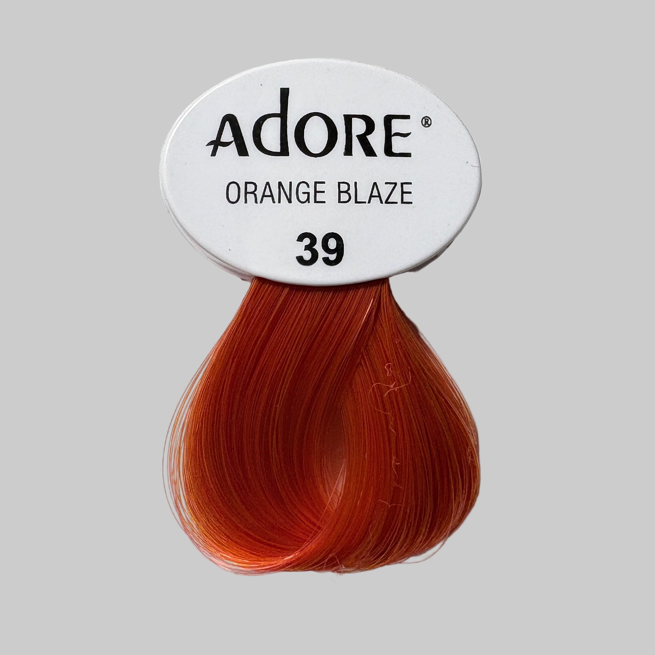 Adore Orange Blaze hair color packaging with a swatch on a shelf.