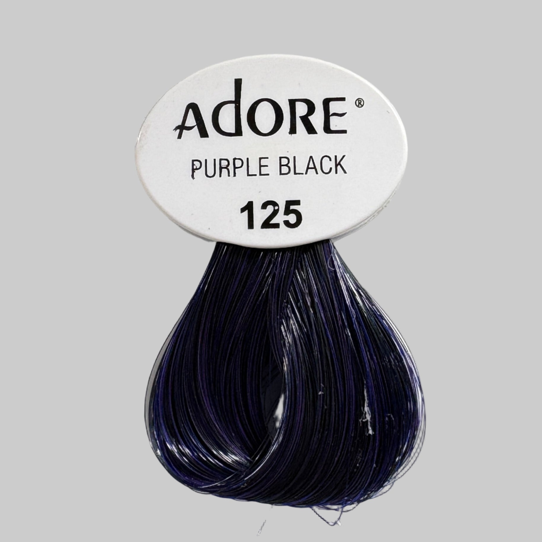Adore Purple Black hair color packaging on a shelf with other products.