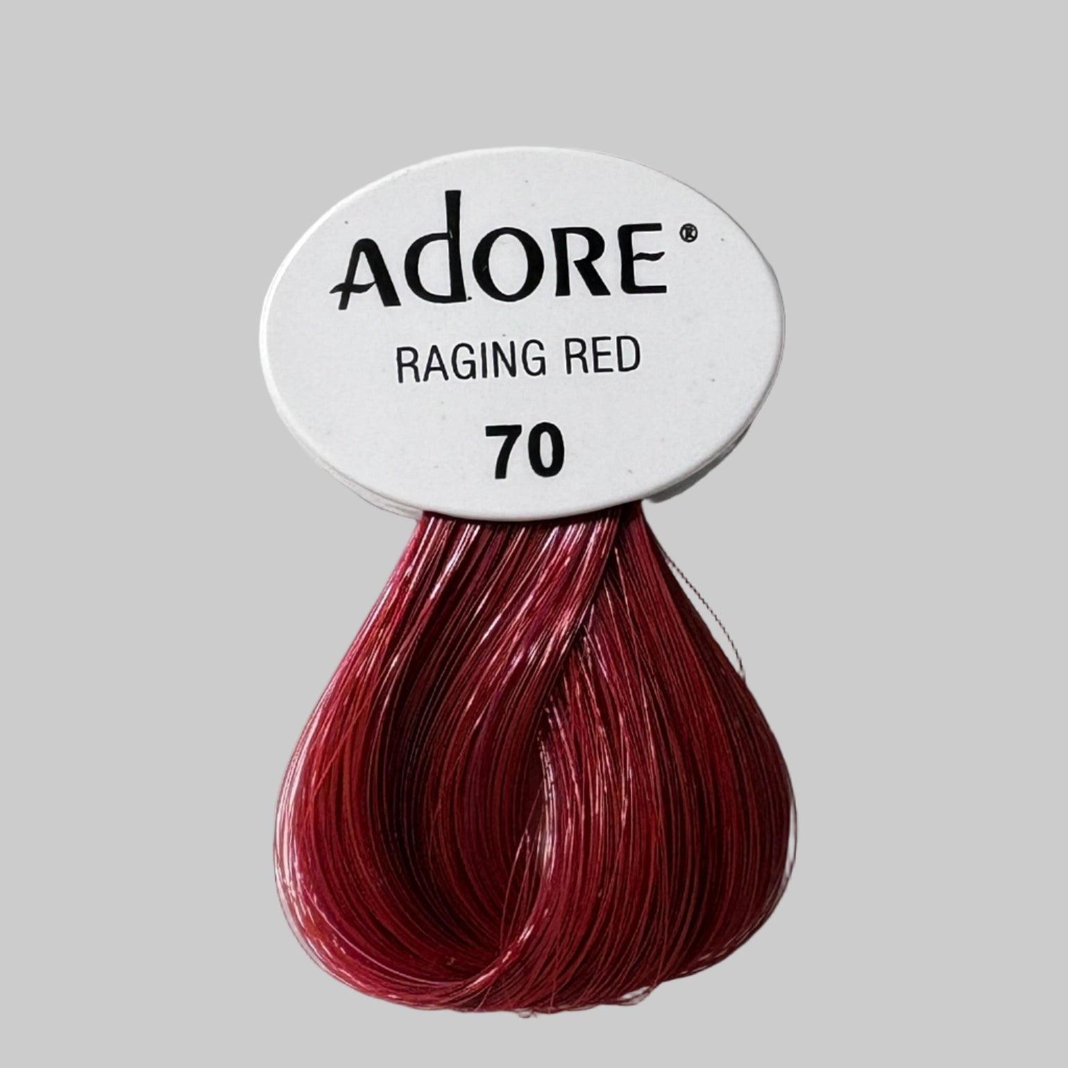 Adore hair dye packaging with red color swatch on a display of other products.