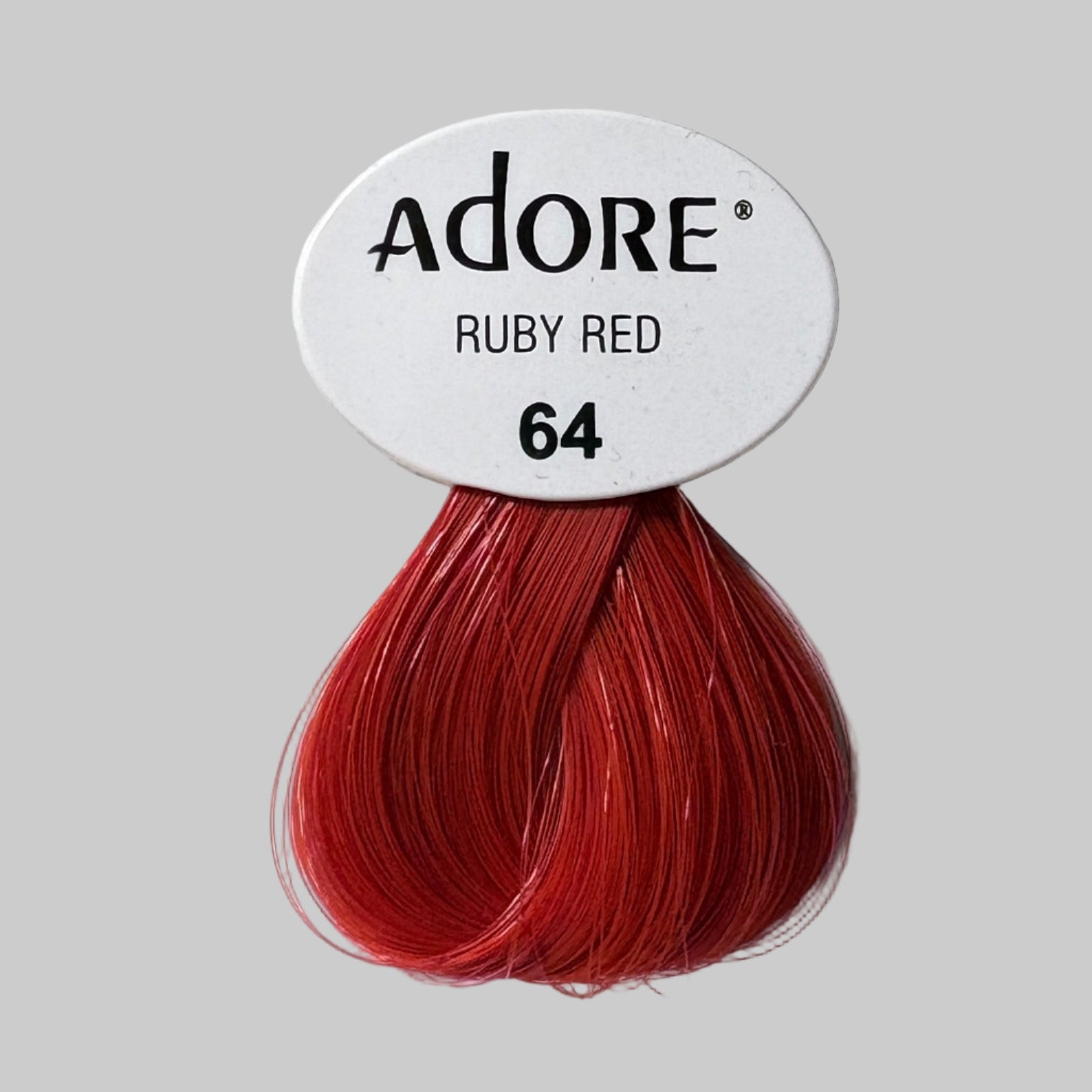 Adore Ruby Red hair color packaging on a shelf with other hair color boxes.