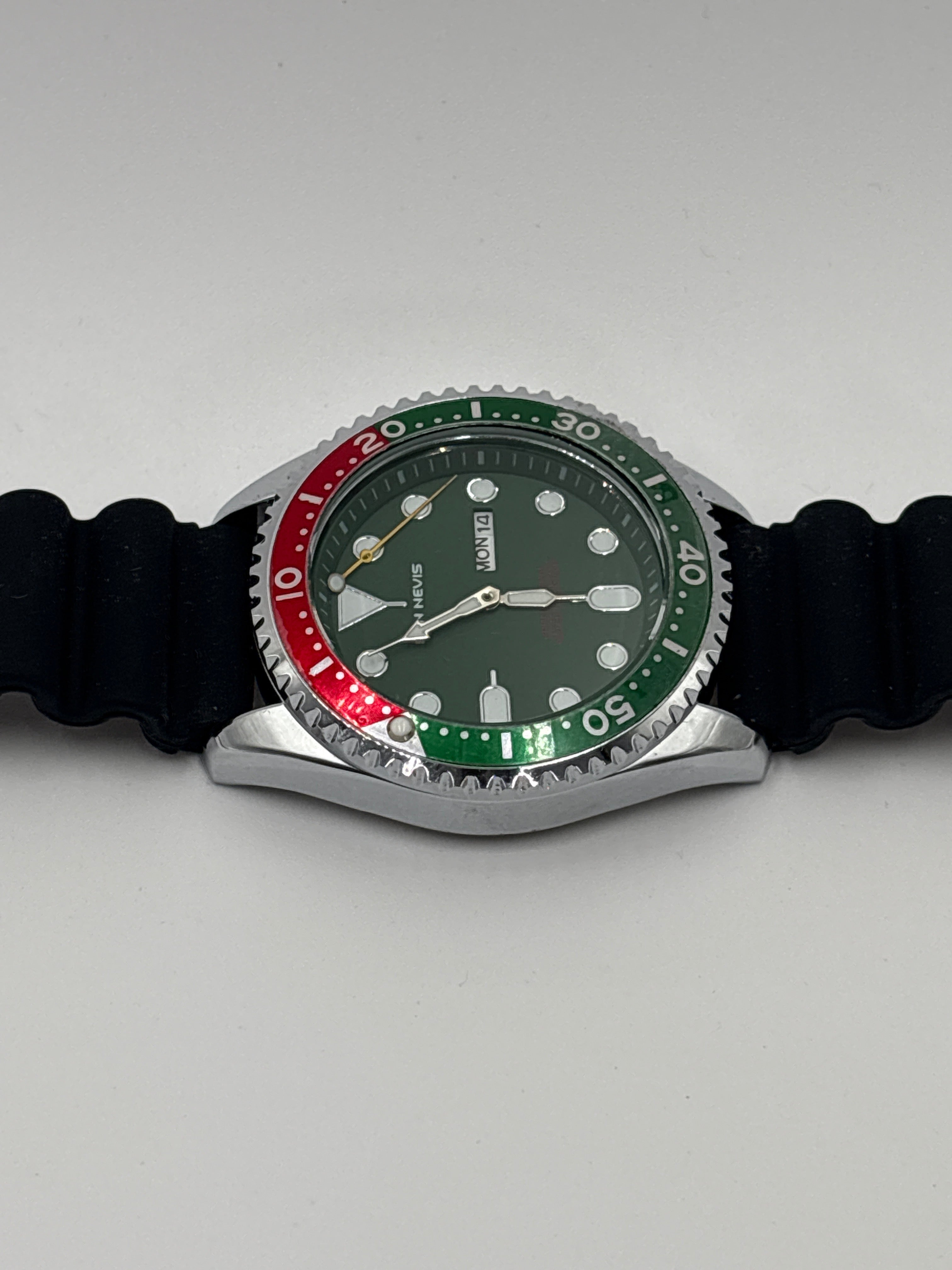 Ben Nevis green red watch with black strap and silver bezel showcasing day and date feature