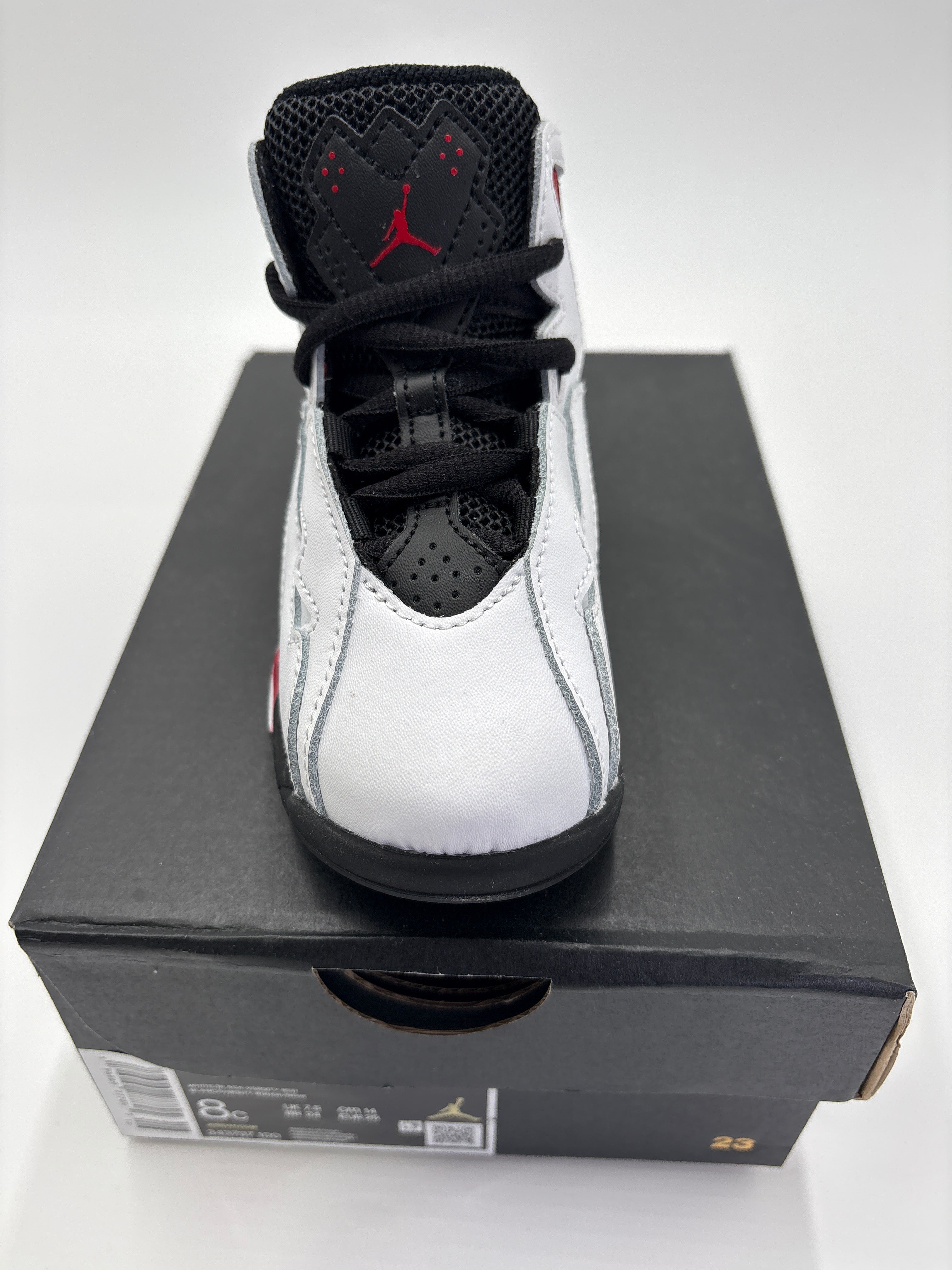 Jordan True Flight toddler shoes in white black and red on a black shoebox from DOLLARS UNIVERSE LLC
