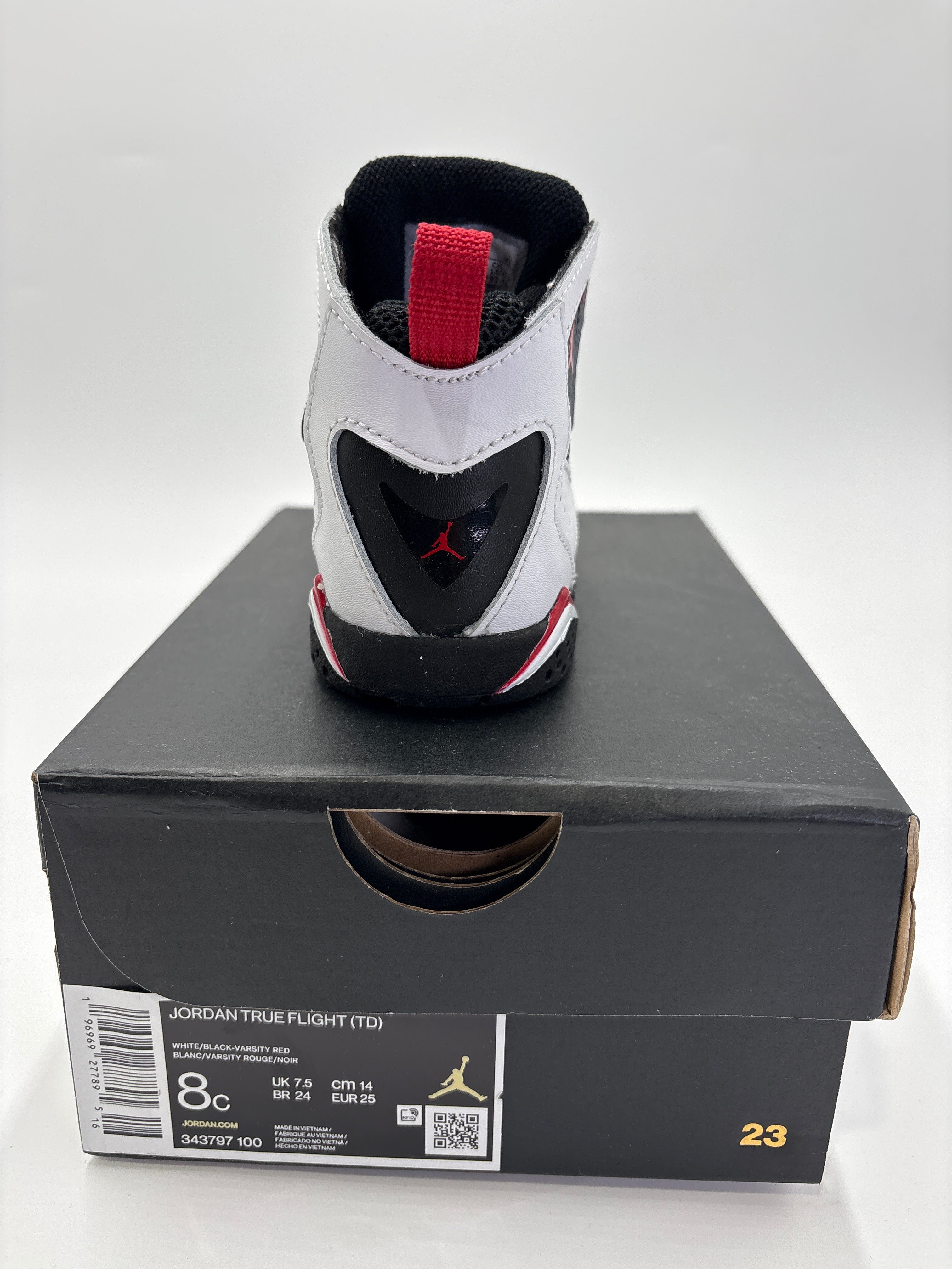 Back view of Jordan True Flight toddler shoes in white black and red on black shoebox