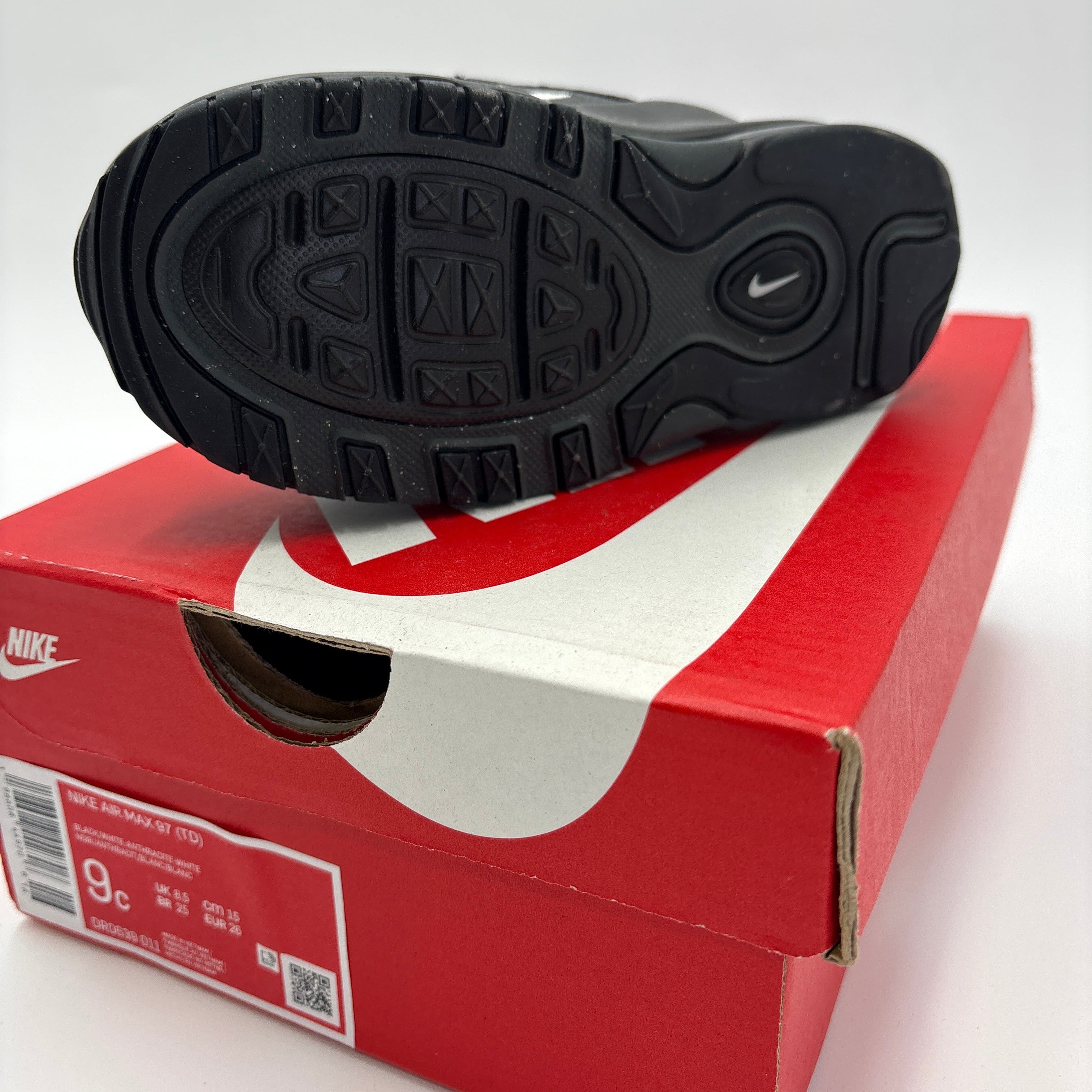 Black sole view of Air Max 97 TD for toddlers displayed on a red Nike shoe box by DOLLARS UNIVERSE LLC