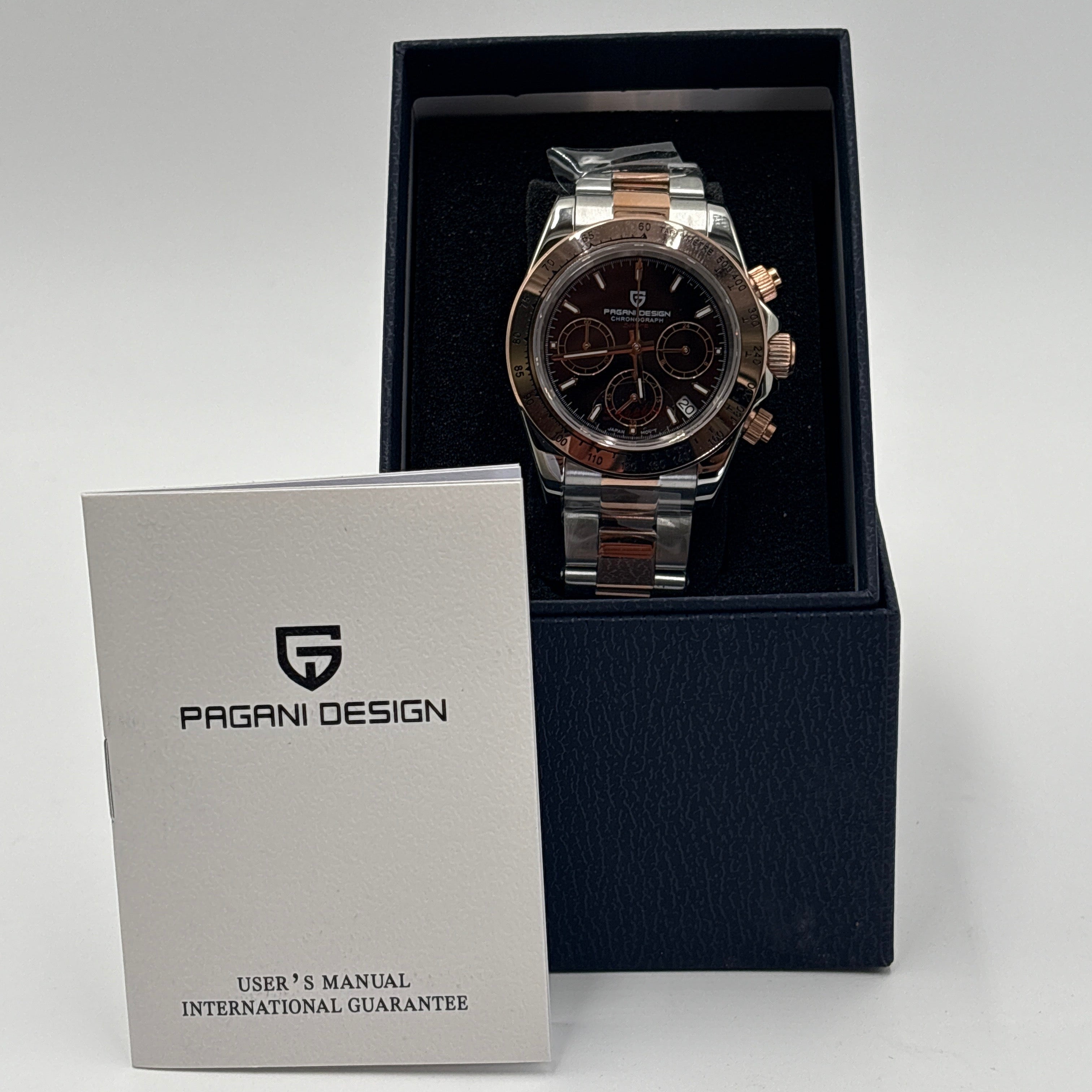 Pagani Design chrome gold watch with black dial in a black box alongside user manual from DOLLARS UNIVERSE LLC