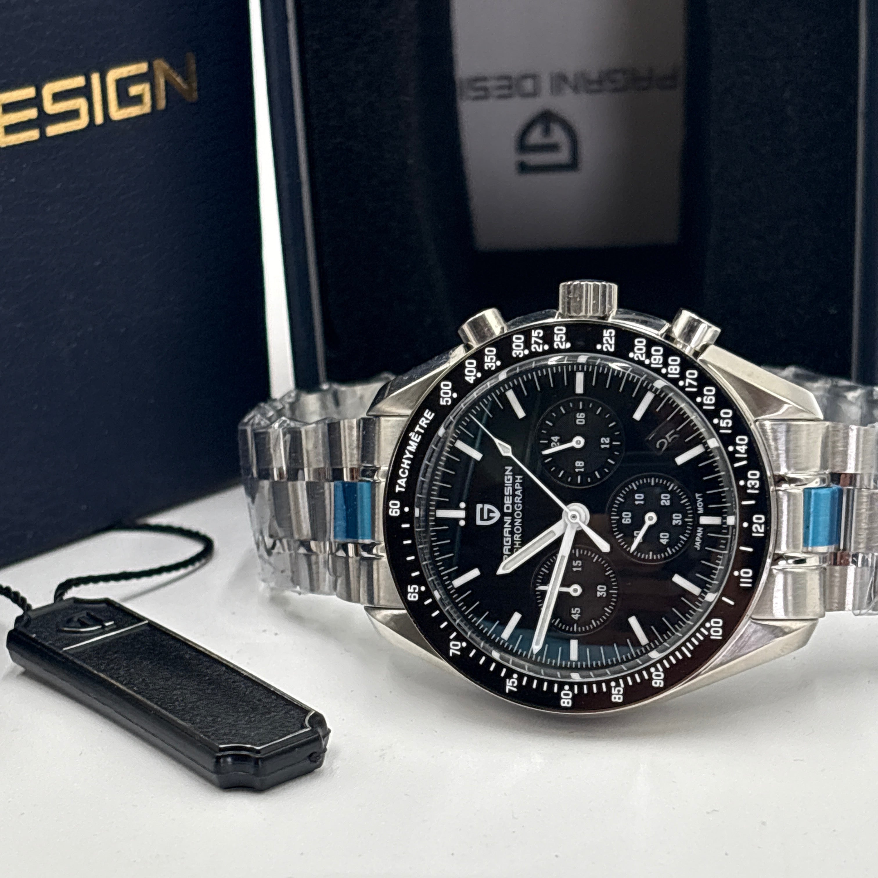 Pagani Design men’s watch with black dial and silver stainless steel band next to branded box and tag