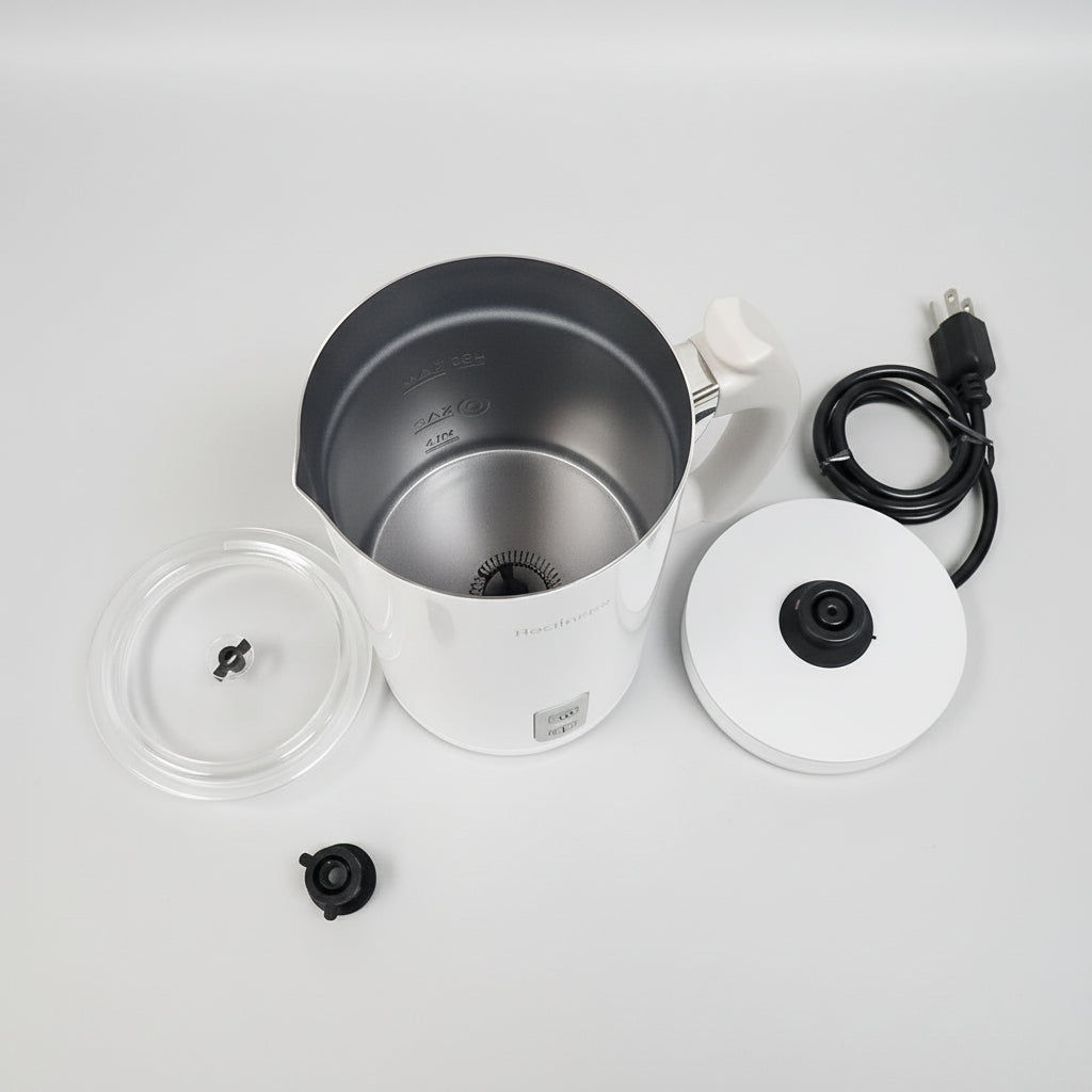 Coffee brewing equipment including a pot, filter, and power cord on a textured white surface.